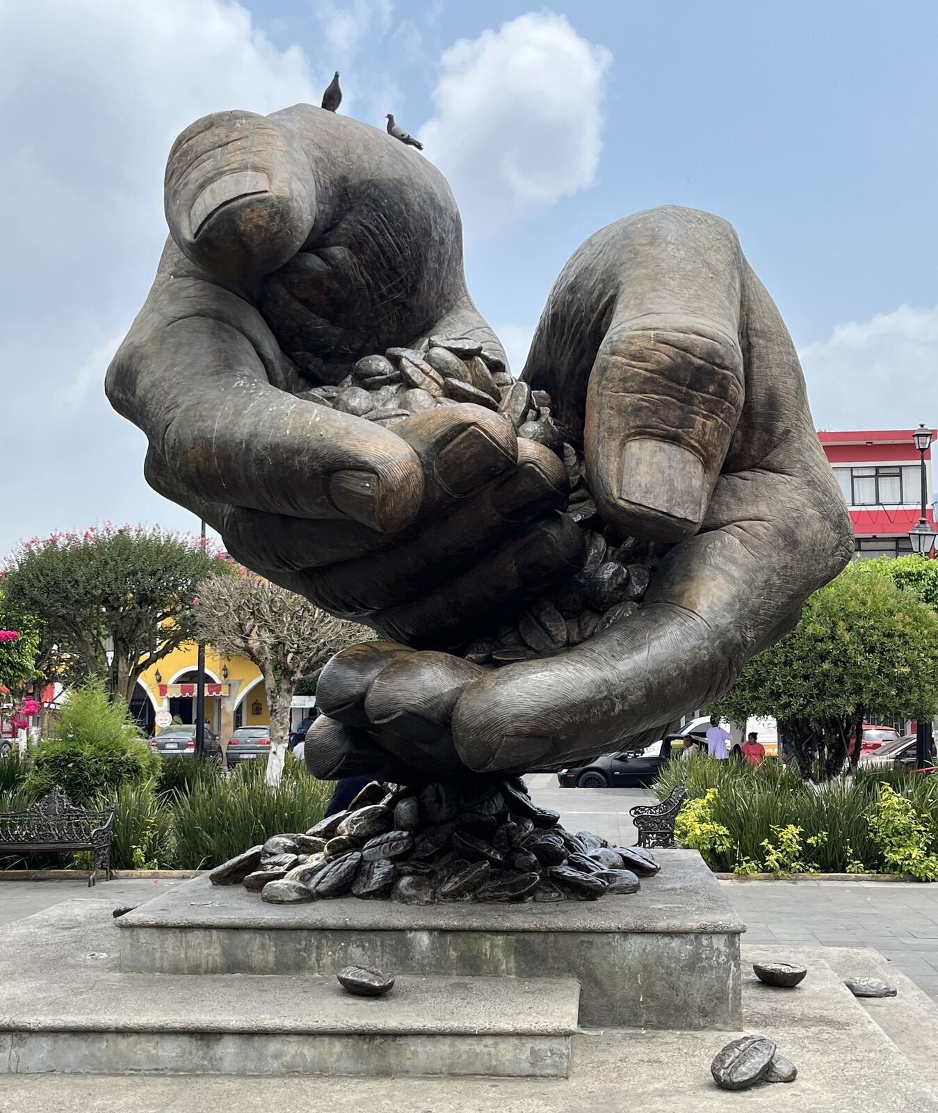 Escultura monumental de manos sosteniendo granos de café, símbolo de la región cafetalera.